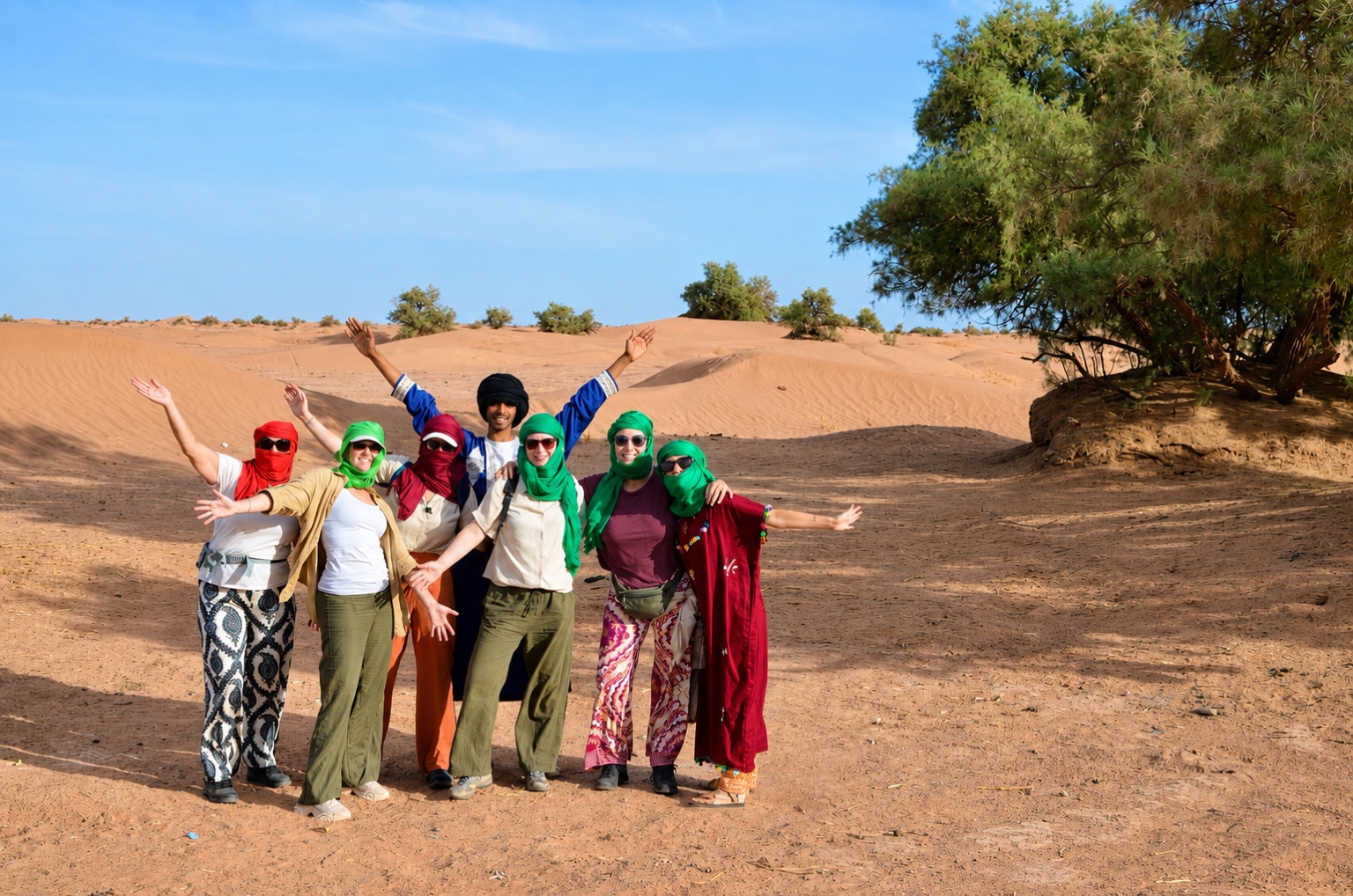 Yoga retreat group gathered in the Sahara dunes.